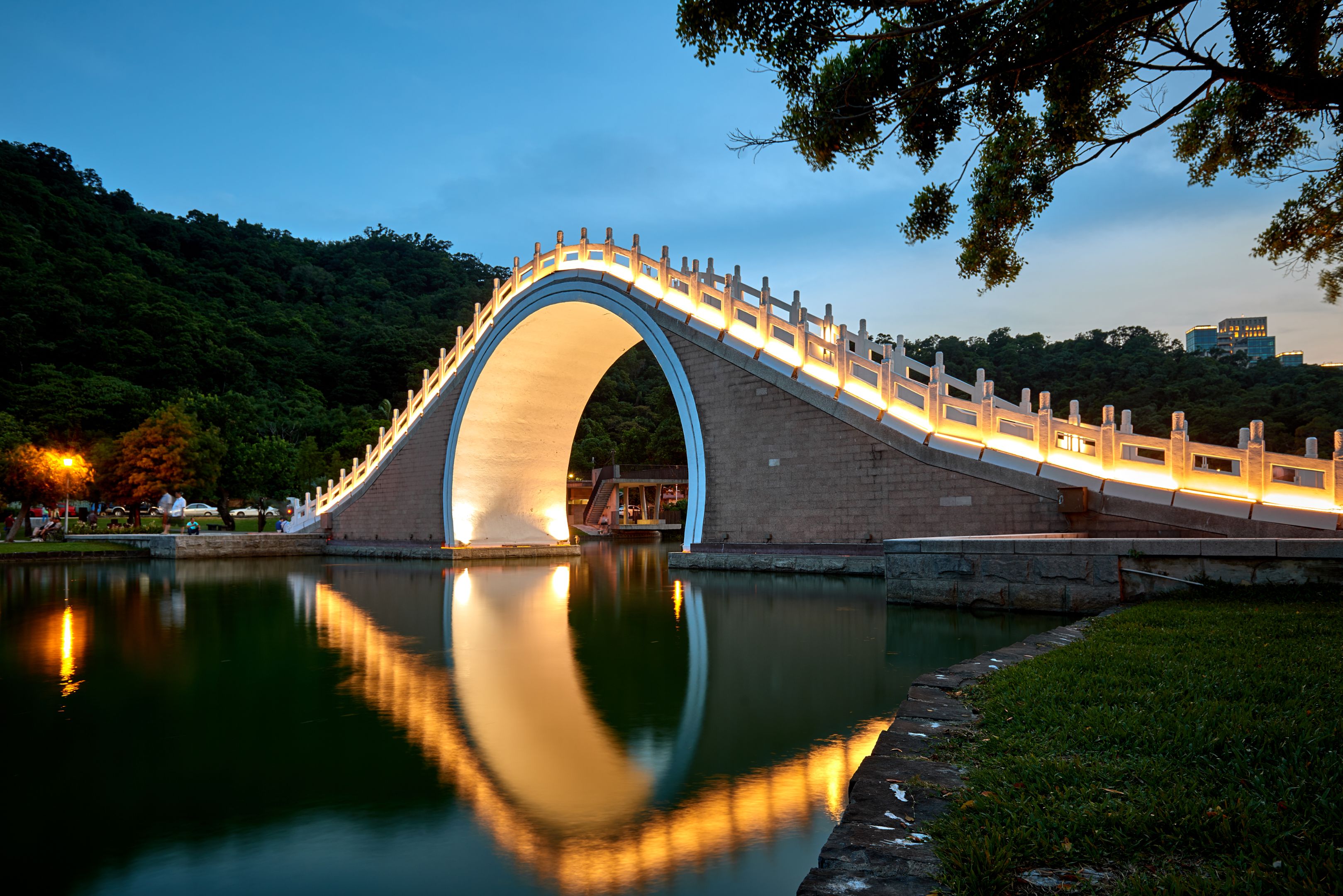 Reflection of the Dahu bridge in the water after the sunset in Taipei Park, Taiwan