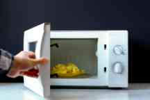 closeup photo of man use  microvave oven to heat the food f