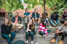 Student ambassadors sit at the steps outside on campus and socialise