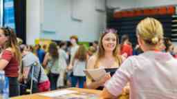 A student talks with a student adviser at a university event 