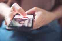 Finger of woman pushing heart icon on screen in mobile smartphone application. Online dating app..