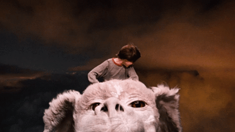 Bastian from The Neverending Story rides through the sky on Atreyu’s back