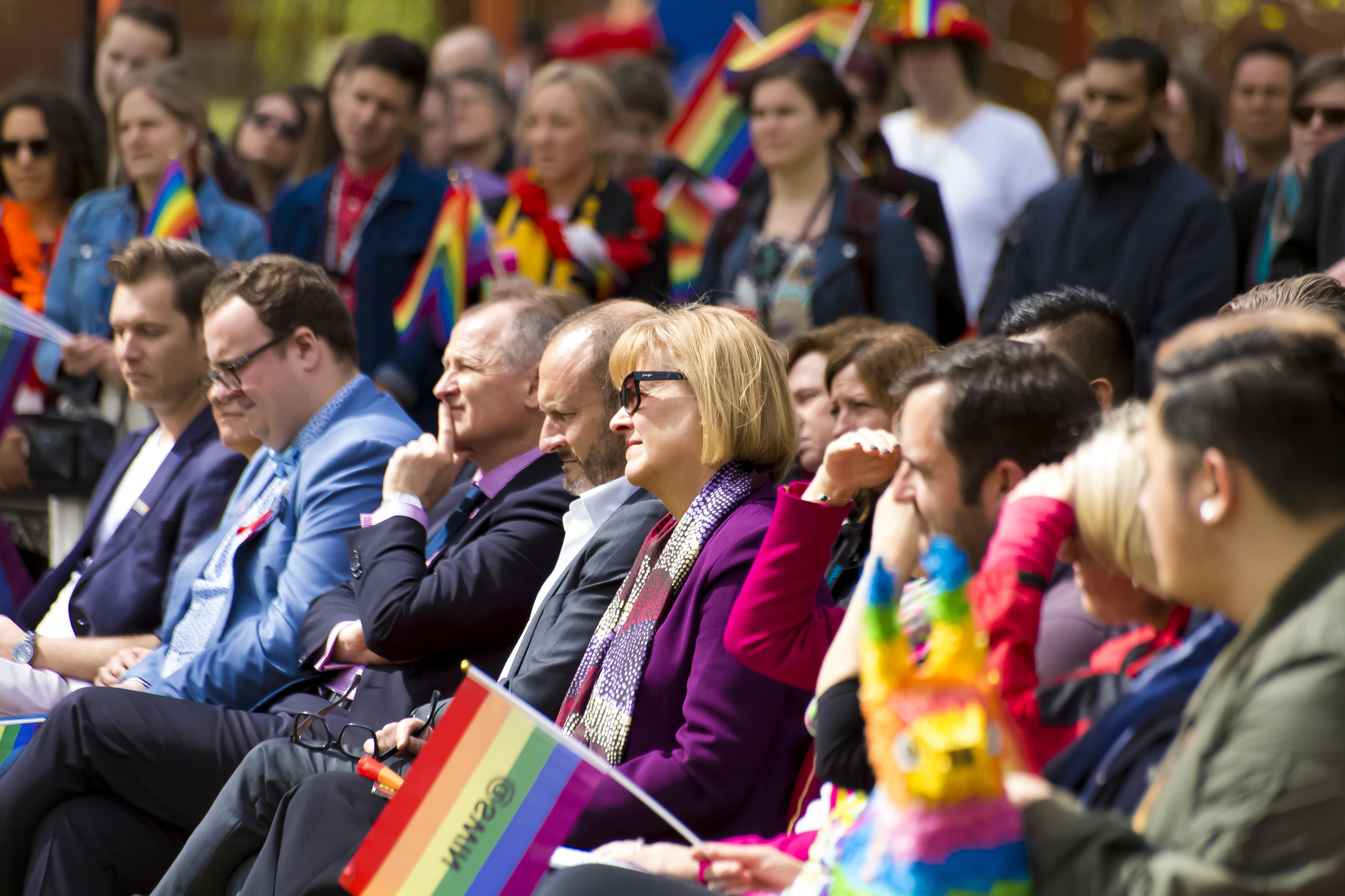 A crowd of people hold rainbow flags as they attend the Pride Day event held on campus 