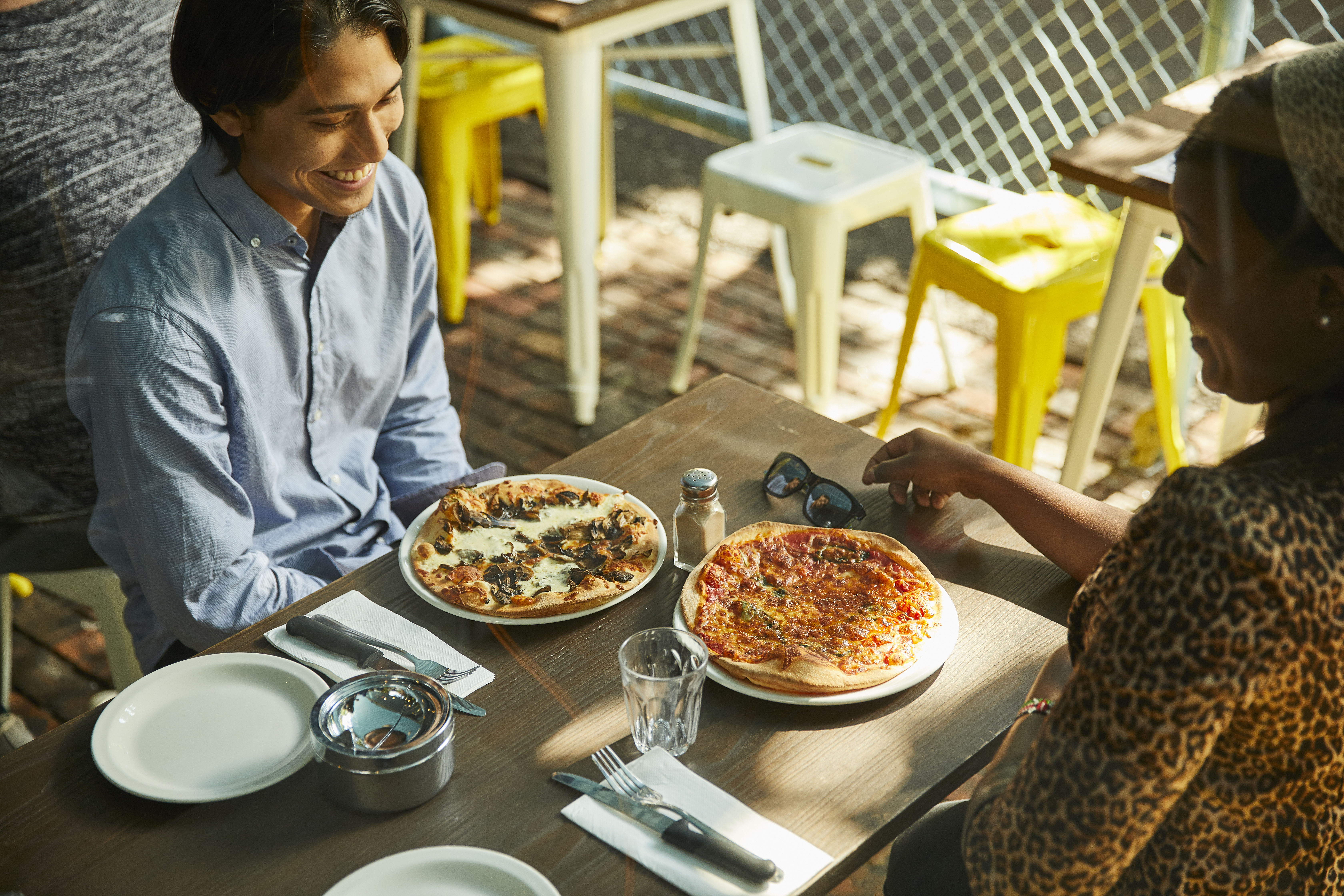 Two students eat pizza at an eatery in a Hawthorn laneway