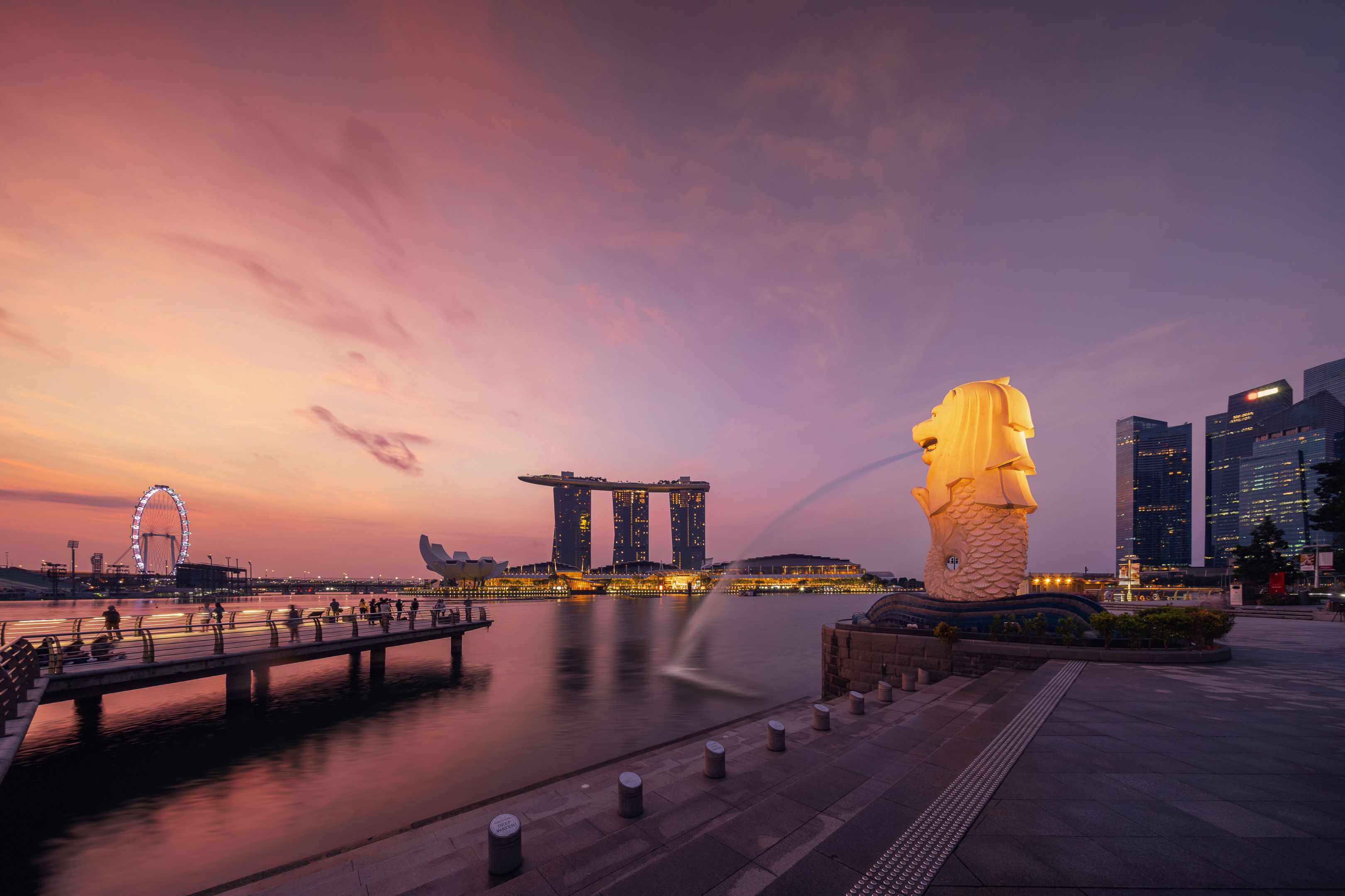 Singapore City - July 29, 2018 : Merlion and Marina Bay Sands at sunrise with Singapore Flyer and twilight sky.