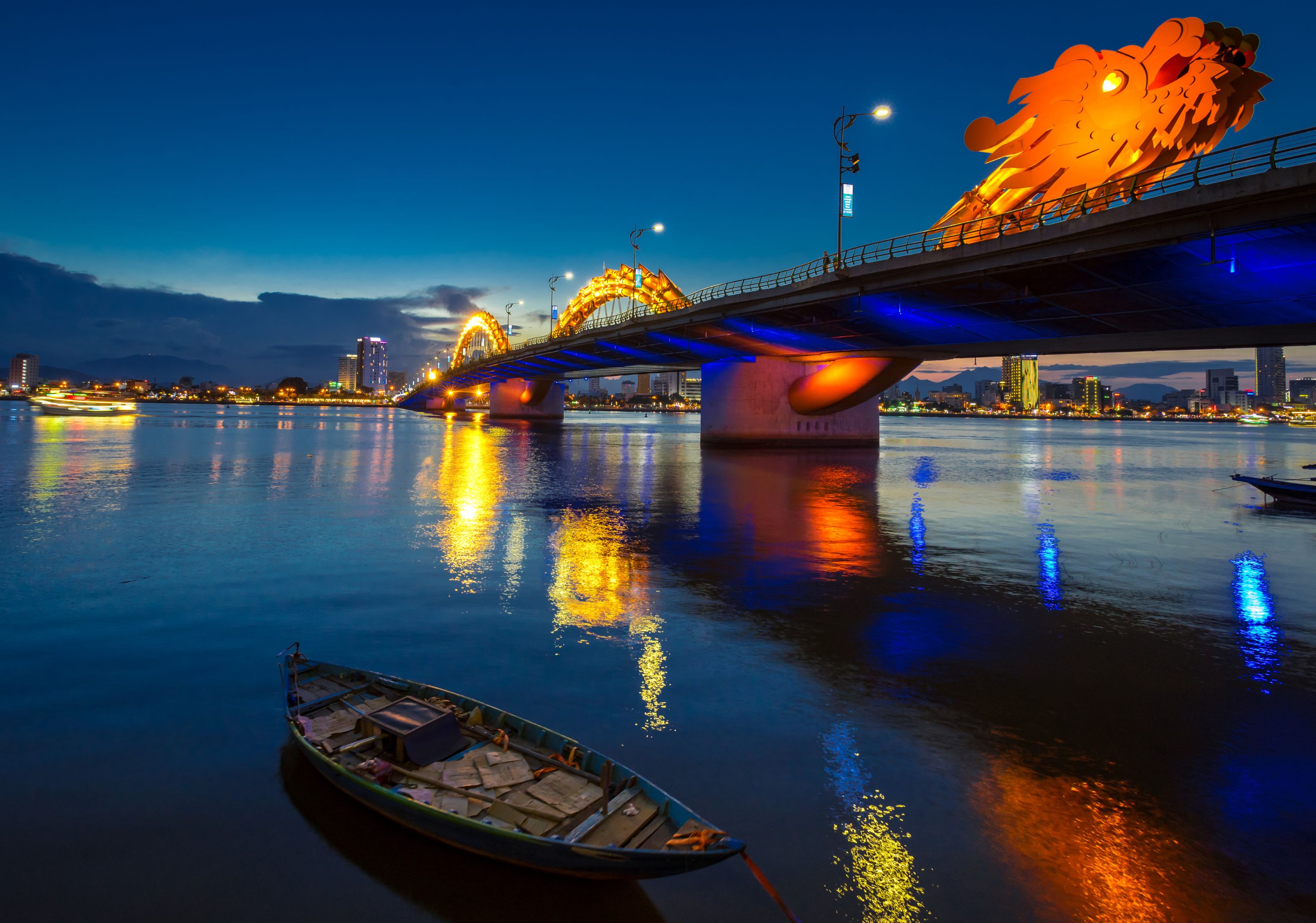 Dragon Bridge in Danang at night, with reflections on the river.