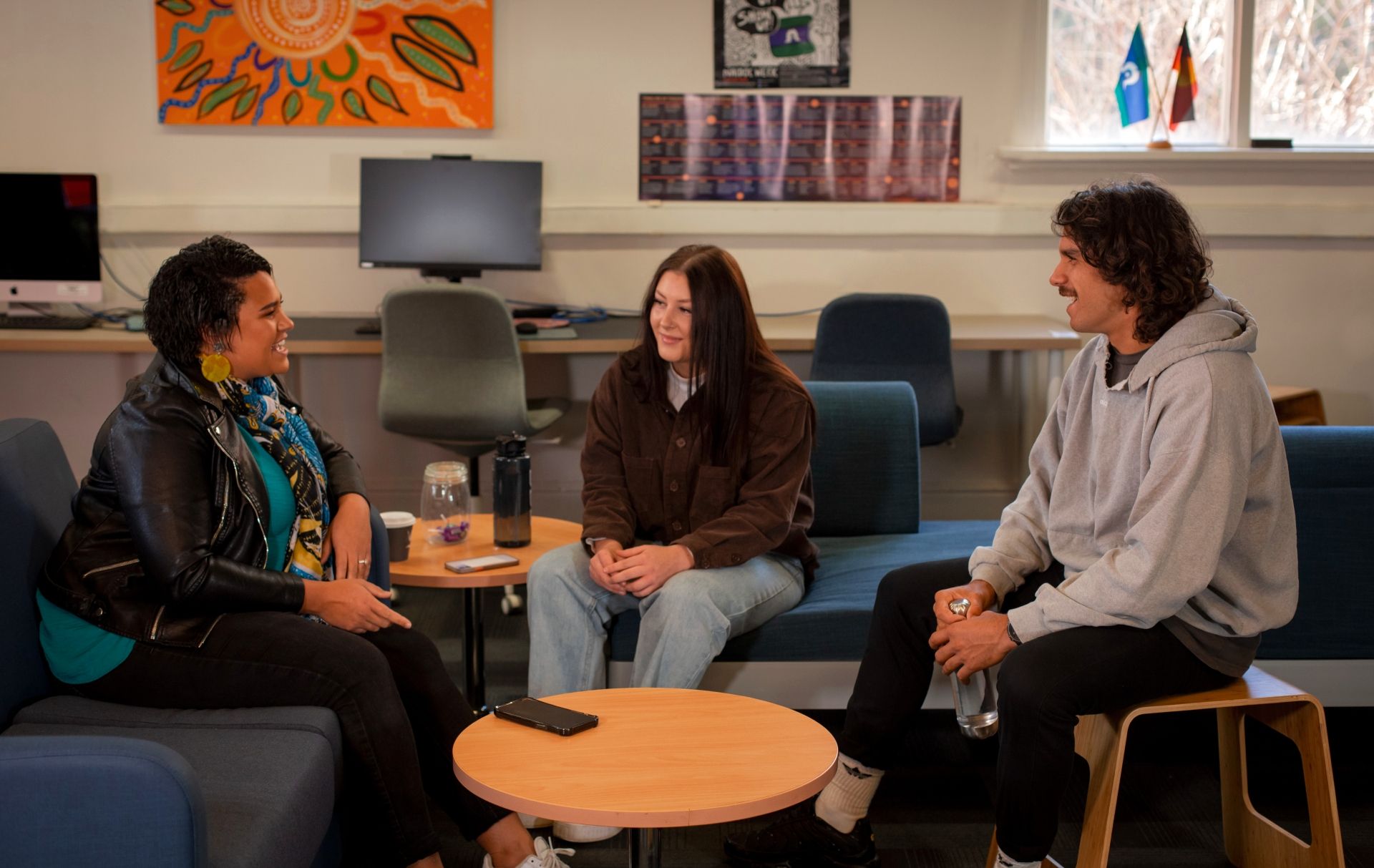 Three students having a conversation in the Indigenous Student Lounge.