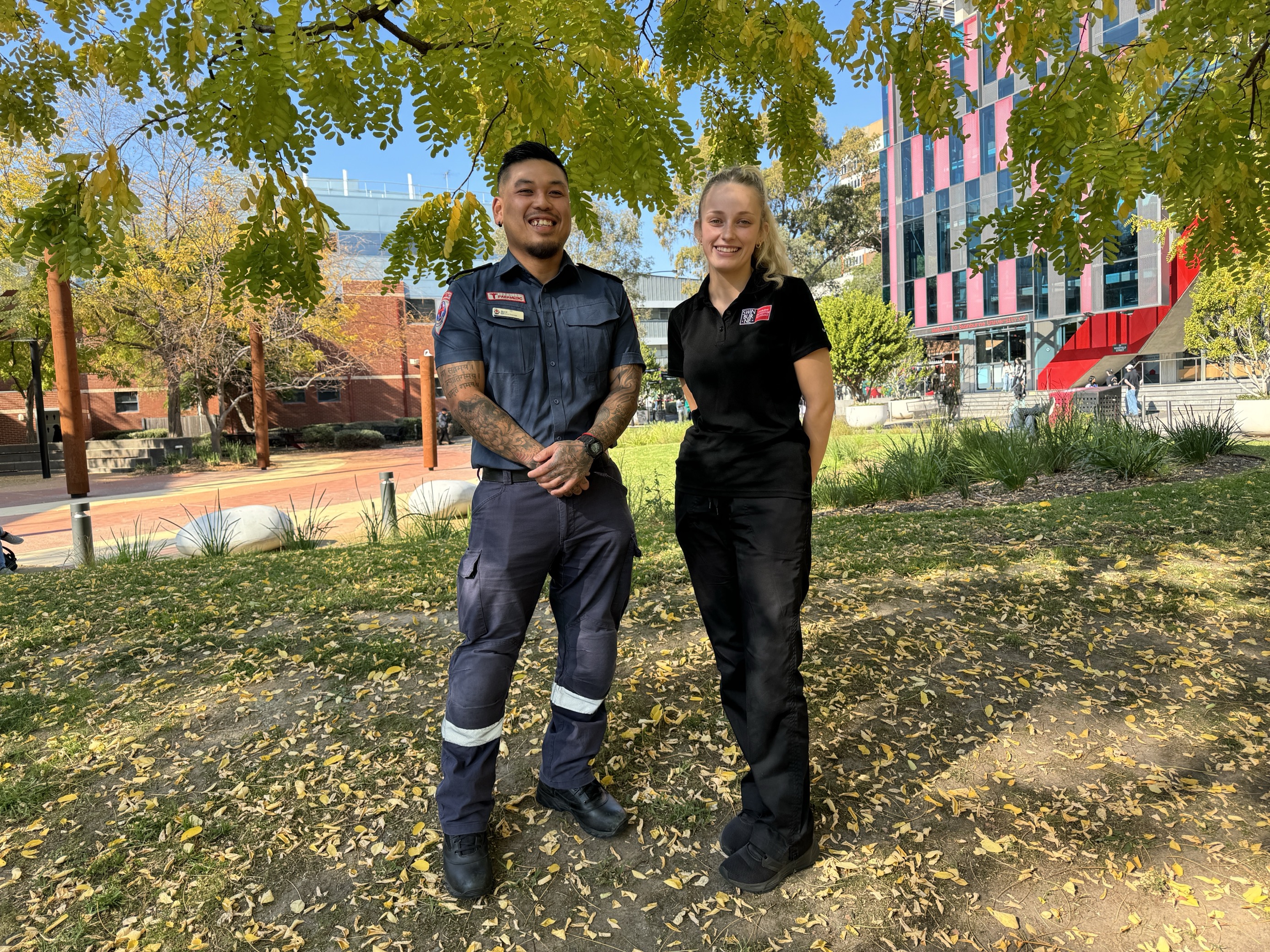 a nurse and paramedic stand together in a grassy area