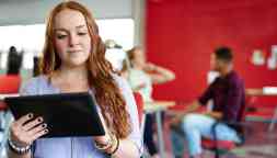 Confident redhead female designer working on a digital tablet in